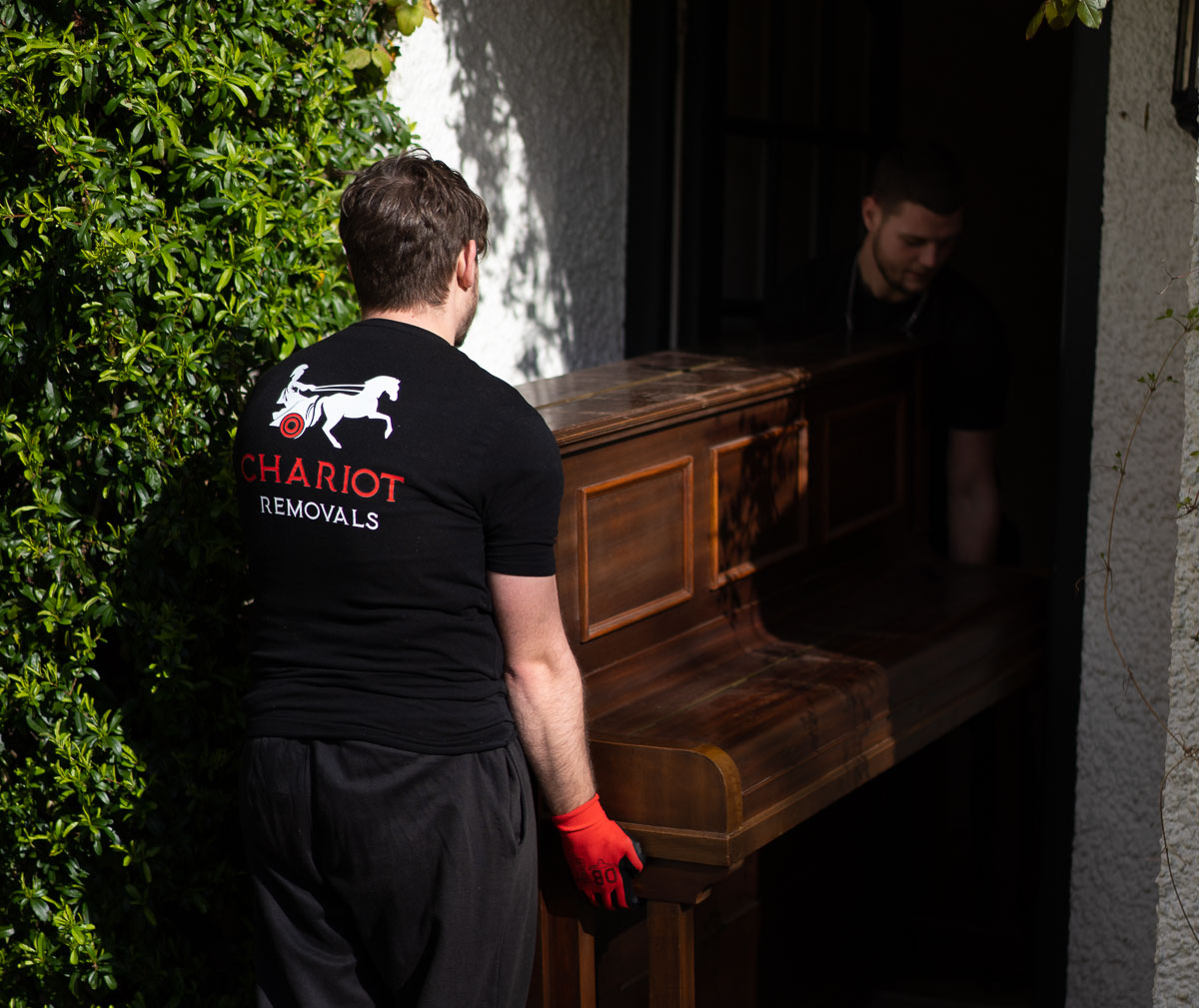 Chariot movers moving piano in the house